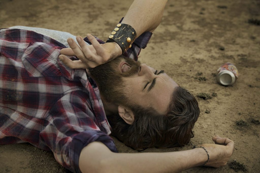 Man with full beard lying on soil